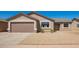 Tan single-story home features a two car garage and low maintenance gravel yard at 4542 N 86Th Dr, Phoenix, AZ 85037