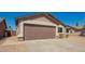 Single-story tan home with two car garage and gravel yard at 4542 N 86Th Dr, Phoenix, AZ 85037