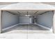An open garage showcases a gray interior with a water heater and light shining inside the garage at 4542 N 86Th Dr, Phoenix, AZ 85037