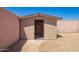 Close up of a backyard storage shed with desert landscaping and a pink cinder block fence at 4542 N 86Th Dr, Phoenix, AZ 85037