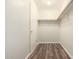 Well-lit walk-in closet featuring hardwood floors and built-in shelving and a door at 4542 N 86Th Dr, Phoenix, AZ 85037