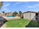 Landscaped backyard with a refreshing swimming pool, basketball hoop, and convenient storage shed at 5046 W Monte Cristo Ave, Glendale, AZ 85306