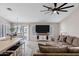 Open concept living room featuring a large sectional sofa, ceiling fan, and sliding door to backyard patio at 5046 W Monte Cristo Ave, Glendale, AZ 85306