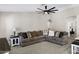Comfortable living room featuring a cozy L-shaped sofa and modern ceiling fan at 5046 W Monte Cristo Ave, Glendale, AZ 85306