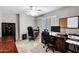 Functional office space with a desk, two chairs, a ceiling fan, window with shutter, and carpeted floor at 5046 W Monte Cristo Ave, Glendale, AZ 85306