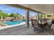 View of the pool and patio through the covered patio featuring a dining table and seating at 5046 W Monte Cristo Ave, Glendale, AZ 85306