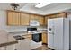 Practical kitchen featuring wood cabinetry, a double sink, and white appliances at 537 S Delaware Dr # 224, Apache Junction, AZ 85120