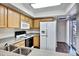 Practical kitchen featuring wood cabinetry, a double sink, and white appliances and exterior access at 537 S Delaware Dr # 224, Apache Junction, AZ 85120