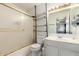 Simple bathroom featuring a shower-tub combination with glass doors and shelving at 6207 N 21St Dr, Phoenix, AZ 85015