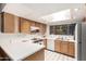 Bright kitchen featuring white countertops, oak cabinets, stainless appliances, and a skylight at 6207 N 21St Dr, Phoenix, AZ 85015