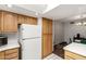 Functional kitchen featuring oak cabinets, a white refrigerator, and tile floors at 6207 N 21St Dr, Phoenix, AZ 85015