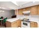 Well-lit kitchen with oak cabinets, white countertops, and a view to the dining area at 6207 N 21St Dr, Phoenix, AZ 85015