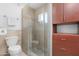 Bathroom featuring a glass shower with pebble floor and wooden cabinets at 654 W Plata Ave, Mesa, AZ 85210