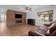 Comfortable living room features a wooden accent wall with fireplace and ceiling fan at 654 W Plata Ave, Mesa, AZ 85210