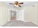 Bedroom featuring neutral walls, carpet, ceiling fan, window and access to an outdoor patio at 7045 S 42Nd St, Phoenix, AZ 85042