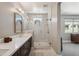 A modern bathroom with a glass enclosed shower and dual vanity with white countertops at 7464 E Paraiso Dr, Scottsdale, AZ 85255