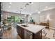 Open concept Kitchen with stainless appliances, dark cabinets, and an island with seating at 7464 E Paraiso Dr, Scottsdale, AZ 85255