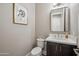 A modern powder room features a stylish mirror, floating vanity, and decorative art at 7464 E Paraiso Dr, Scottsdale, AZ 85255
