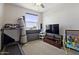Bedroom with a ceiling fan, window, treadmill, and television for at home exercise and leisure at 7531 E Billings St # 116, Mesa, AZ 85207