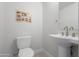Powder room featuring white sink, toilet, and a whimsical corgi-themed art print at 7531 E Billings St # 116, Mesa, AZ 85207