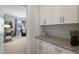Hallway with built-in white cabinets and granite countertops; a bedroom can be seen through the open door at 7531 E Billings St # 116, Mesa, AZ 85207