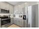 Modern kitchen with stainless steel refrigerator, range, and microwave oven with white countertops at 7531 E Billings St # 116, Mesa, AZ 85207