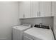Laundry room with white cabinets, a washing machine, and a dryer for convenient home laundry at 7531 E Billings St # 116, Mesa, AZ 85207