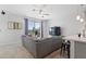 Bright living room featuring a gray sofa, modern ceiling fan, and sliding glass doors to the outside patio at 7531 E Billings St # 116, Mesa, AZ 85207