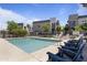 Community pool with lounge chairs, surrounded by modern townhome exteriors and green landscaping on a sunny day at 7531 E Billings St # 116, Mesa, AZ 85207