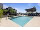 Community pool features ample seating, sun shade, and modern townhomes in the background at 7531 E Billings St # 116, Mesa, AZ 85207