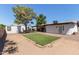 Large backyard with artificial turf, gravel landscaping, covered patio, and detached building at 8111 E Jerome Ave, Mesa, AZ 85209