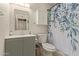Well-lit bathroom featuring a vanity, cabinet, toilet, and shower with a floral curtain at 8111 E Jerome Ave, Mesa, AZ 85209