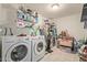 Functional laundry room with modern washer and dryer, ample storage shelving, and tiled floor at 8111 E Jerome Ave, Mesa, AZ 85209