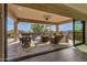 This covered patio features patio furniture, a ceiling fan, and overlooks the pool area at 9059 E Leonora St. St, Mesa, AZ 85207