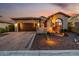 Inviting desert home featuring a paver driveway, two-car garage, and mature landscaping under a colorful dusk sky at 9059 E Leonora St. St, Mesa, AZ 85207