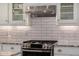 Gourmet kitchen featuring stainless steel gas range, white subway tile, and white cabinetry at 9059 E Leonora St. St, Mesa, AZ 85207