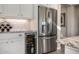 Modern kitchen featuring a stainless steel refrigerator, built-in wine cooler, white cabinetry, and granite counters at 9059 E Leonora St. St, Mesa, AZ 85207