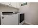 This laundry room has a modern washer and dryer with white cabinets above at 9059 E Leonora St. St, Mesa, AZ 85207