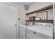 Bright laundry room with washer, dryer and floating shelves at 9223 E Camino Del Santo --, Scottsdale, AZ 85260