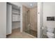 Tiled shower stall with pebble floor, glass door, and a walk-in closet nearby at 9223 E Camino Del Santo --, Scottsdale, AZ 85260