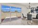 Dining room with modern chandelier, glass table, and views of the backyard patio at 9707 W Lancaster Dr, Sun City, AZ 85351