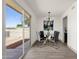 Dining room featuring modern chandelier, glass table, and backyard patio access at 9707 W Lancaster Dr, Sun City, AZ 85351