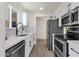 Modern kitchen featuring stainless steel appliances, white cabinets, and tile floors at 9707 W Lancaster Dr, Sun City, AZ 85351
