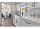 Bright kitchen featuring white cabinets, modern faucet and a view into the dining area at 9707 W Lancaster Dr, Sun City, AZ 85351