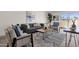 Bright living room with stylish gray sofa, patterned rug, and large windows at 9707 W Lancaster Dr, Sun City, AZ 85351