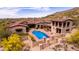Aerial view of a luxurious home with a private pool, patio and desert landscaping at 9820 E Thompson Peak Pkwy # 628, Scottsdale, AZ 85255