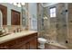 Bathroom featuring beautiful granite countertops, wood cabinets, and an enclosed tiled glass shower with a window at 9820 E Thompson Peak Pkwy # 628, Scottsdale, AZ 85255