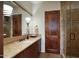 Well-lit bathroom featuring a granite countertop, dark wood cabinets, and a glass-enclosed shower at 9820 E Thompson Peak Pkwy # 628, Scottsdale, AZ 85255