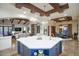 Modern kitchen flows into the living and dining areas; a large central island and a beamed ceiling are notable features at 9820 E Thompson Peak Pkwy # 628, Scottsdale, AZ 85255