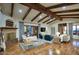 Spacious living room featuring a stone fireplace, wood floors, beamed ceiling, and multiple seating areas at 9820 E Thompson Peak Pkwy # 628, Scottsdale, AZ 85255